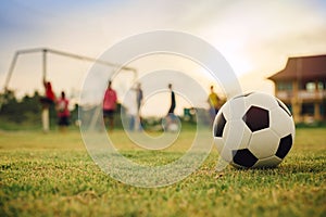 Silhouette action sport outdoors of a group of kids having fun playing soccer football for exercise in community under