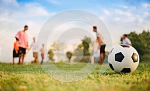 Silhouette action sport outdoors of a group of kids having fun playing soccer football for exercise in community under