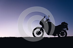 silhouette adventurous motorcycle on blue sunset sky, motorcycle touring background, adventure and travel concept, active