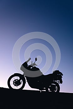 silhouette adventurous motorcycle on blue sunset sky, motorcycle touring background, adventure and travel concept, active