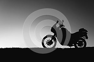 silhouette adventurous motorcycle on blue sunset sky, motorcycle touring background, adventure and travel concept, active