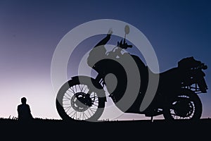 silhouette adventurous motorcycle on blue sunset sky with people, motorcyclists, motorcycle touring background, adventure and