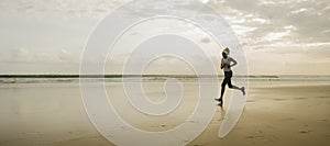 Silhouette of African American woman running on the beach - young attractive and athletic black girl training outdoors doing