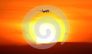 Silhouette of airplane departing arriving during sunset at tropical paradise Bali Indonesia.