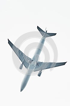 Silhouette of an airplane on sky background. Commercial airplane jetliner flying above clouds in beautiful day light. Flight trave