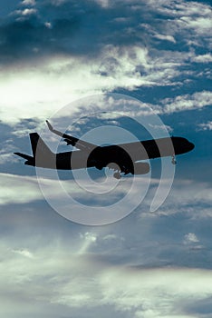 Silhouette of airplane in the sky at sunset with dramatic clouds