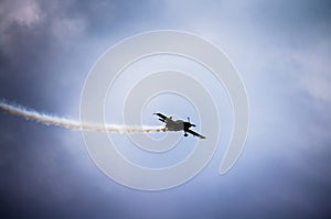 Silhouette of an airplane with smoke;