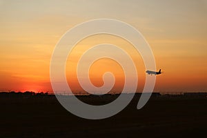 Silhouette of an airplane taking off to the sunset sky