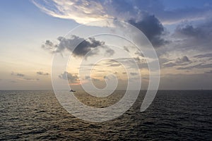 Silhouette of an anchor handling tug boat at oil field during sunrise