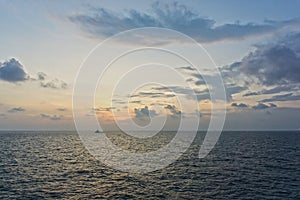 Silhouette of an anchor handling tug boat at oil field during sunrise