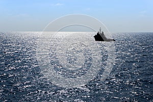 Silhouette of an anchor handling tug boat at oil field during sunrise