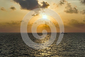 Silhouette of an anchor handling tug boat at oil field during sunrise