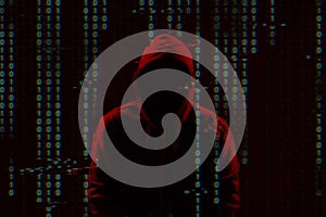 Silhouette of anonymous hacker and digital binary code on dark background. Cyber attack concept