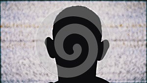 Silhouette of an Anonymous Man`s Head is Watching White Static Noise and TV Interference