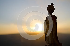 Silhouette of Arab man stands alone in the desert and watching the sunset with clouds of fog. Eastern Fairytale