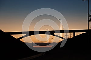 Silhouette of arch bridge at bright sunset