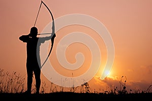 Silhouette archery shoots a bow photo