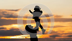 Silhouette of asian mother and daughter in sunset sky. mother and daughter are playing and proud happy together