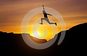 Silhouette of athlete, jumping over rocks in mountain area