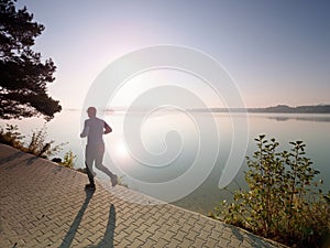Silhouette of athlete run on sunset background copy space