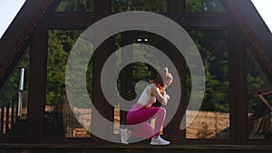 Silhouette of athletic female wearing sportwear rotating neck warming up before morning exercise, muscles warm up to