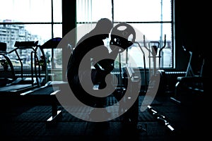 Silhouette of an athletic man working out at gym