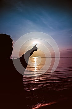 Silhouette back view of woman relax at seaside and pointing to t