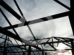 Silhouette background with blue sky, Structure of steel roof frame for building roof construction