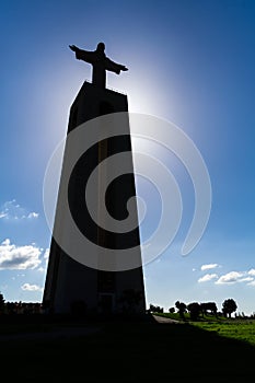 Silhouette or Backlit Cristo-Rei statue on the Cristo Rei or King Christ Sanctuary in Almada.