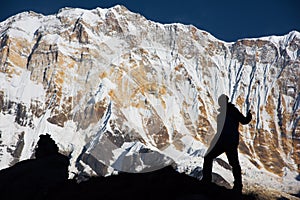 Silhouette backpacker on the rock and Annapurna I Background 8,091m from Annapurna Basecamp ,Nepal.