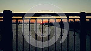 Silhouette of backpackers ride city bike on bridge