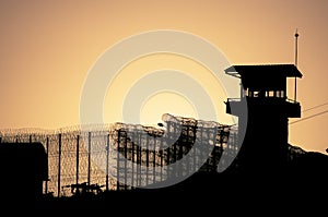 Silhouette of barbed wires and watchtower of prison