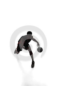 Silhouette of basketball player in motion with ball, make athlete playing isolated on white background