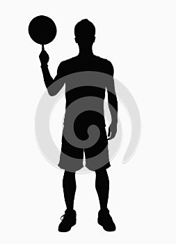 Silhouette of basketball player spinning basketball on finger.
