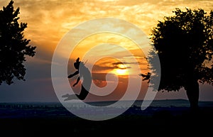 Silhouette of a beautiful girl jumping in the sunset