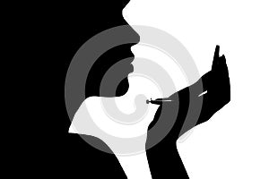 Silhouette of a girl with handpicked hair, profile of a woman face looking in a pocket mirror, the concept of the beauty and fashi