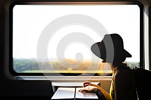 A silhouette of beautiful hipster asian woman traveling on the train.