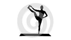 Silhouette Beautiful smiling happy young woman doing yoga exercise on mat, standing in Vrksasana Posture, Tree Pose.