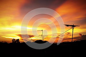 Silhouette of Beautiful sunset with television antenna or telecommunications towers, Orange sky with clouds.