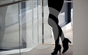 Silhouette of a beautiful woman`s legs, black pants, black shoes, office