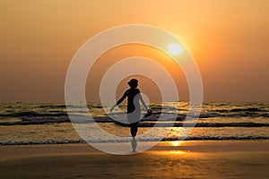 Silhouette of a beautiful young girl on sunset in India, Goa, Ar