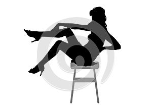 Silhouette of a beautiful young slim girl  with long wavy hair, who is sitting on a bar stool with her legs raised up