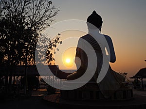 Silhouette of behind Buddha on sunset