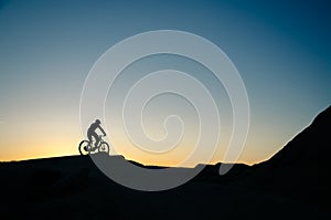 Silhouette of a bicycle in the mountains at sunset