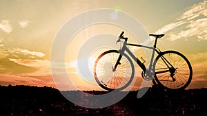 Silhouette of a bicycle parked on the beach in the evening