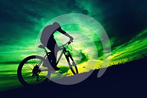 Silhouette of bicyclist against colorful sky at sundown