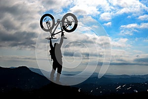 Silhouette bicyclist success on mountaintop