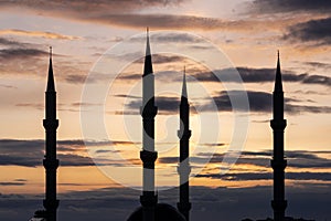 A silhouette of a big mosque against sunset with coudy sky background. Ramadan concept.