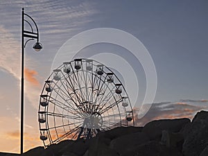 Silhouette of a big wheel against sunset sky, Nobody. Concept fun fair, amusement park, fun