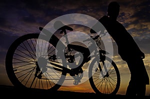 Silhouette of biker with twilight sky